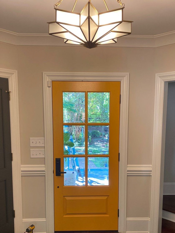 single entry wood door painted yellow beveled glass